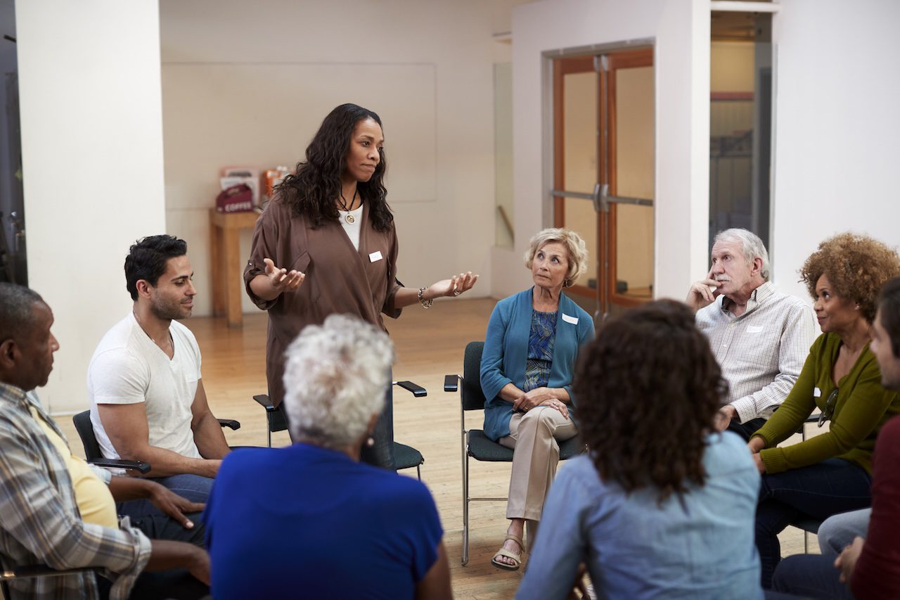 Caregiver resources and support are shared in a group setting for those caring for a loved one with dementia.