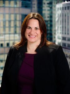 Female in a blazer inside of a work setting background